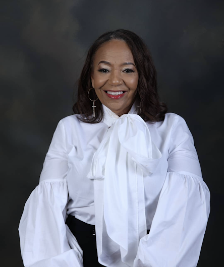 D.L. Augustine in a white blouse